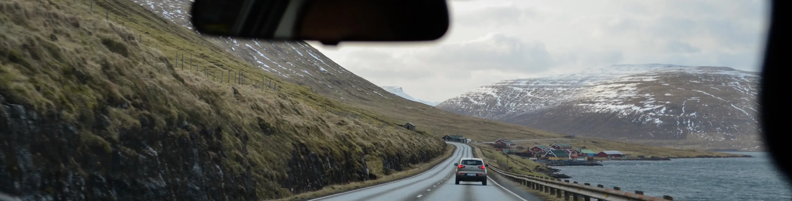 Sjåfør kjører bil på fjellvei